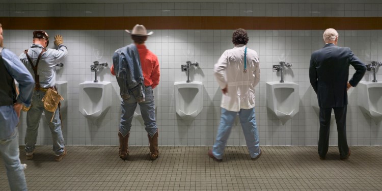 Four men standing at urinal, rear view (digital composite)